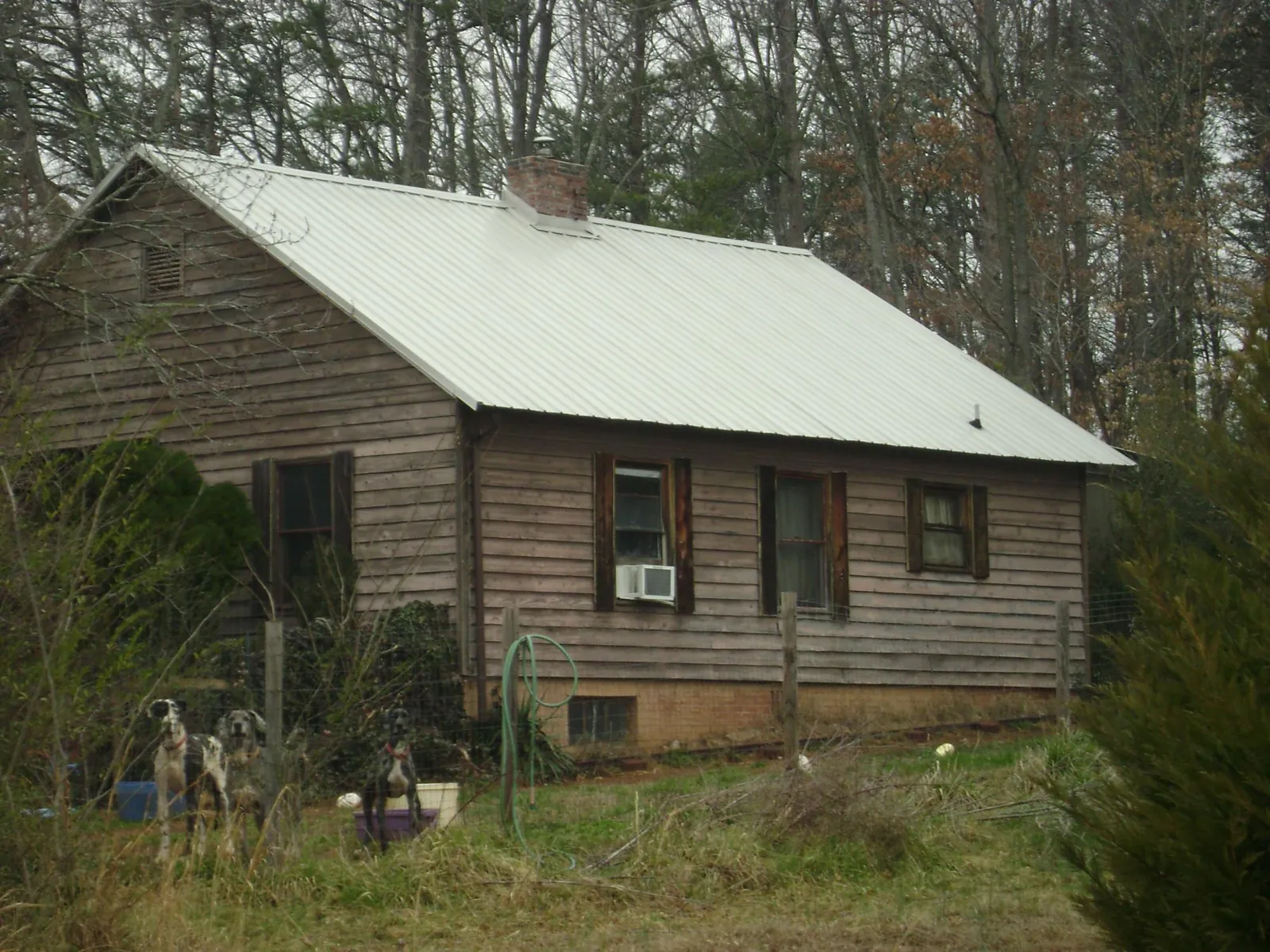 White metal roof on an old wood sided farmhouse, from a Metal Roof Installation job in Lake Park